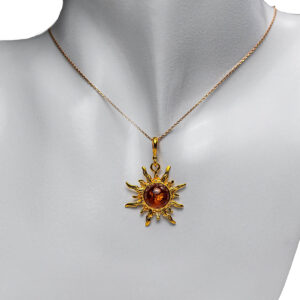 Sudraba kulons saulītes formā ar oranžu dzintara gabaliņu, apzeltīts