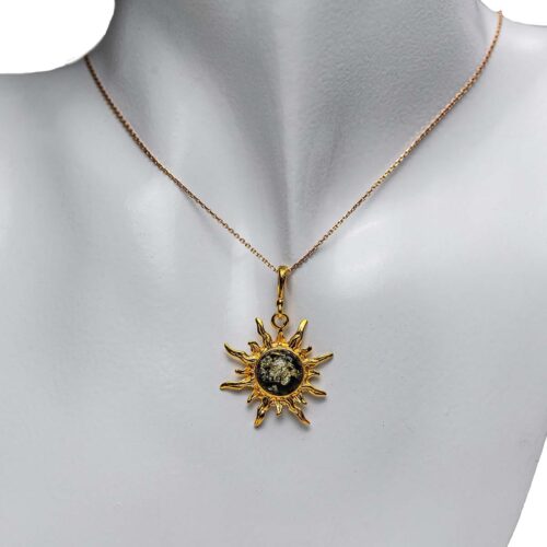 Sudraba kulons saulītes formā ar zaļganu dzintara gabaliņu, apzeltīts