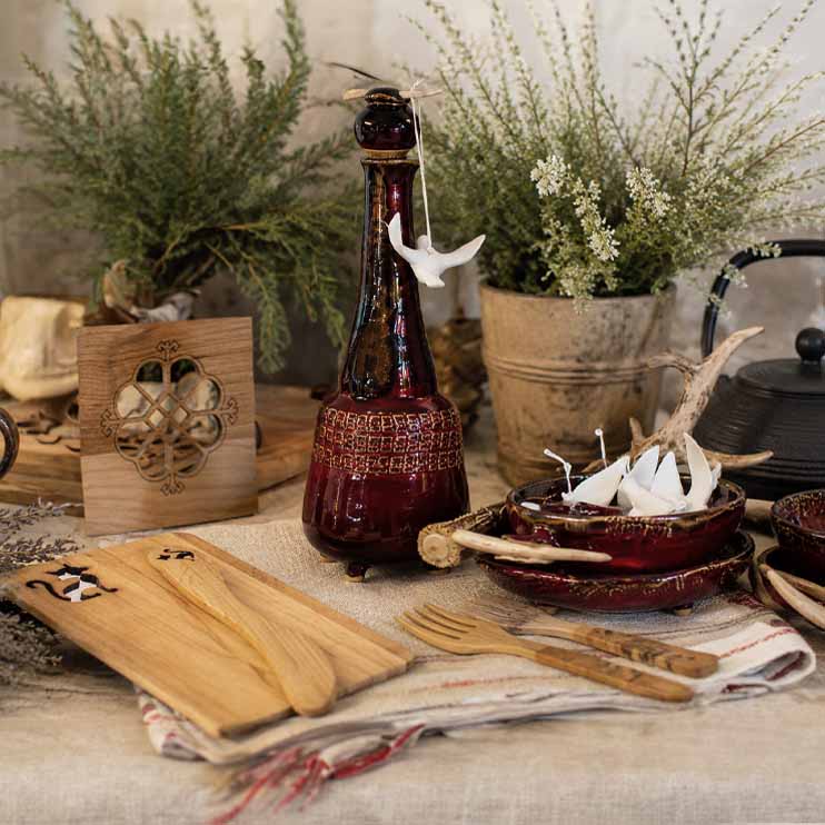 Roku darbs bordo keramikas pudele – tradicionāla amatniecības keramika