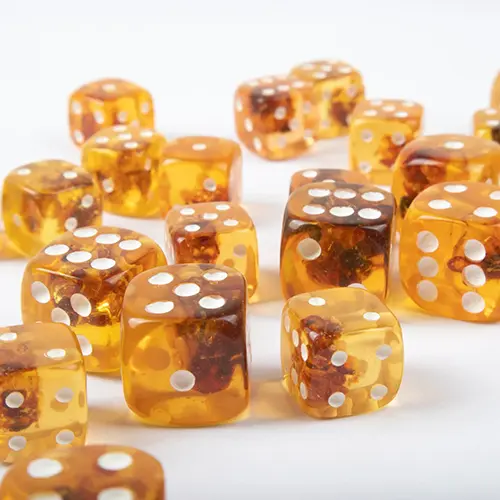 Gaming and decorative dices made of amber with white spots