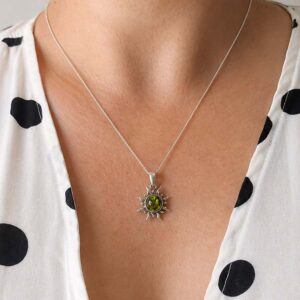 Silver pendant in sun shape with greenish amber piece